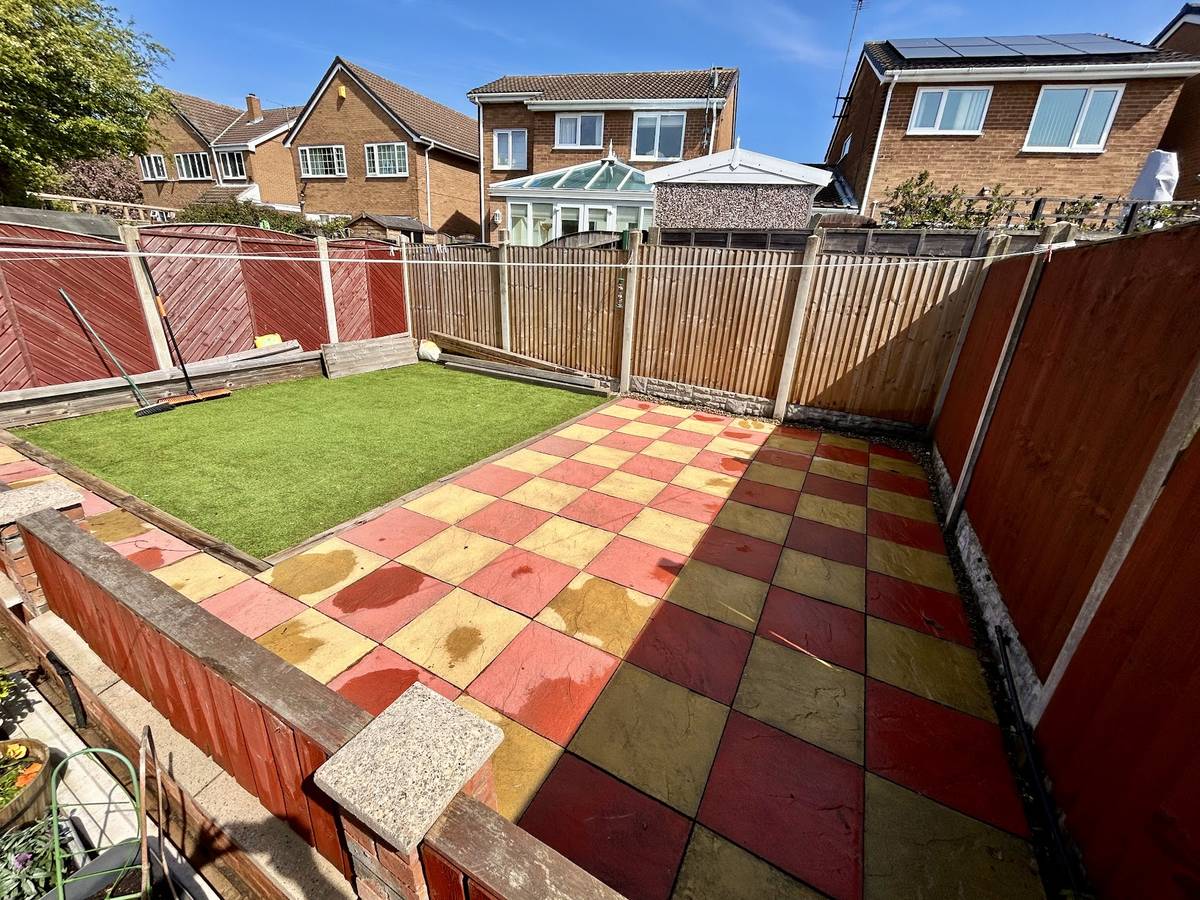 A chequerboard patio cleaned and a lawn cut and edged by Mills Maintenance