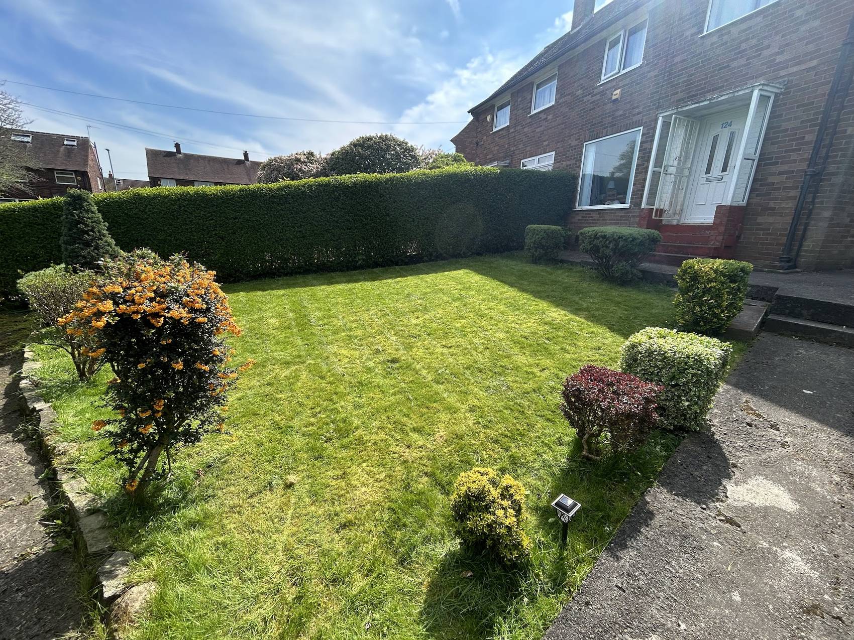 A front lawn freshly cut and edged with shrubs shaped, after a Mills Maintenance visit